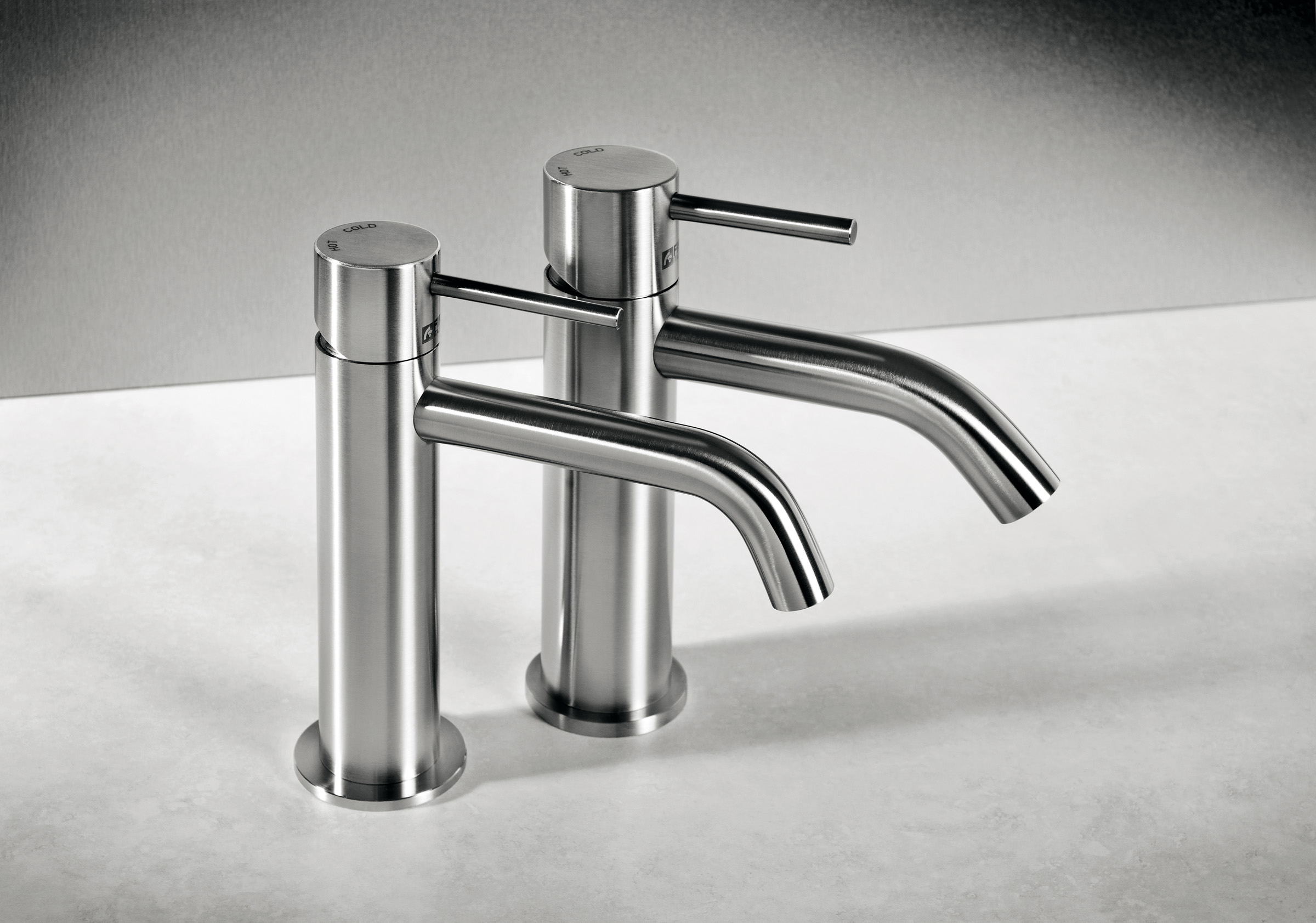 Rubinetto al piano CleoSteel 48 “mini” per lavabo, misura M, e rubinetto al piano CleoSteel 48 per lavabo, misura M. Finitura Acciaio Inox Spazzolato